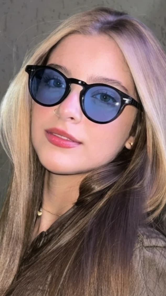 Modelo usando óculos Saint Camille redondo preto com lentes azuis